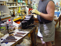 Hand-stitching sheaths at the heavy vise using polyester sinew, one of the toughest, most durable materials made